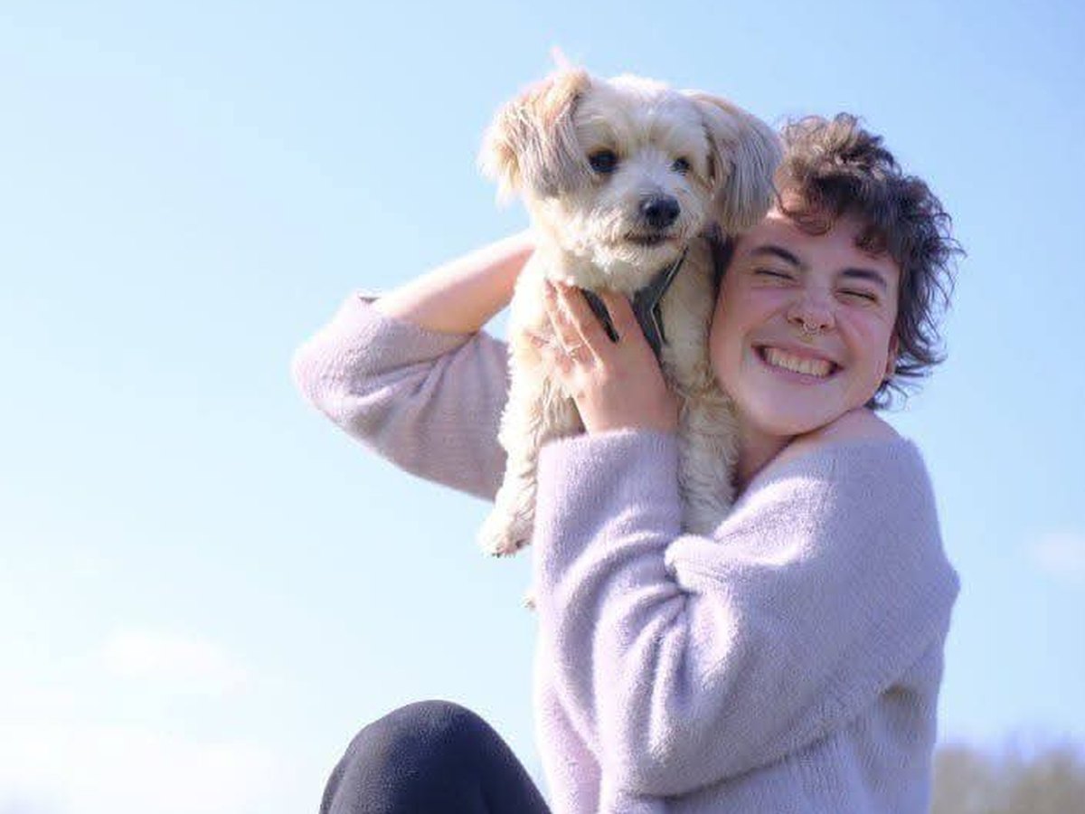 Veer houdt lachend haar hulphond Xip omhoog